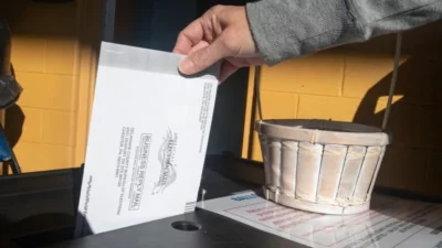 A voter returns their mail ballot. (Charles Fox/Philadelphia Inquirer)