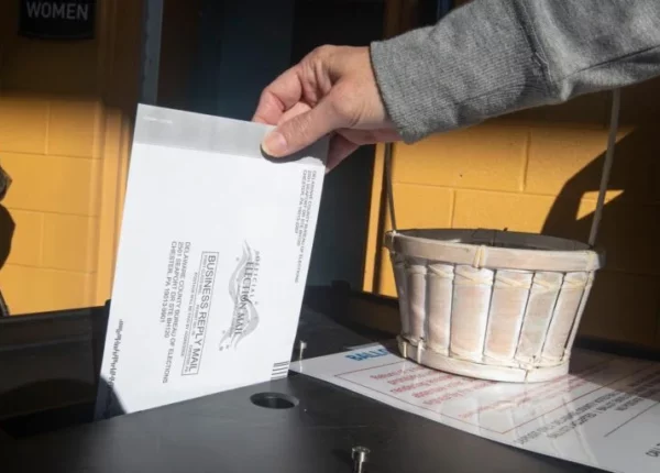 A voter returns their mail ballot. (Charles Fox/Philadelphia Inquirer)