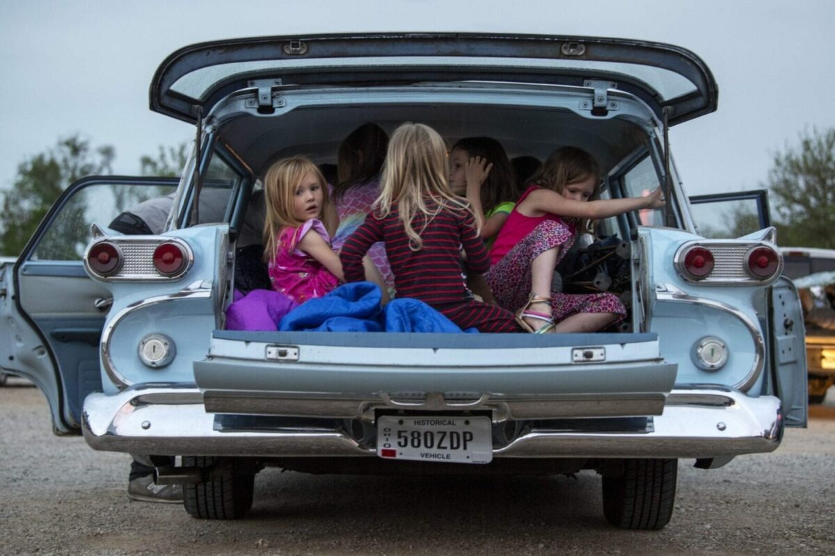 Violet Spencer, 4, left, Josephine Spencer, 6, Jack Spencer, 4, Eloise Turner, 7, and Charlotte Turner, 5, right, pile into Travis and Dianna Spencer’s 1959 Ford Edsel Ranger to watch the 2019 production of The Addams Family at the South Drive-In Theater in Columbus, Ohio, on May 23, 2020. While the South Drive-in Theater was open to the public, certain policies were in place, including requiring masks to purchase snacks, space between cars and space between patrons using the restrooms. (Photograph by Gaelen Morse, AMERICA REIMAGINED)