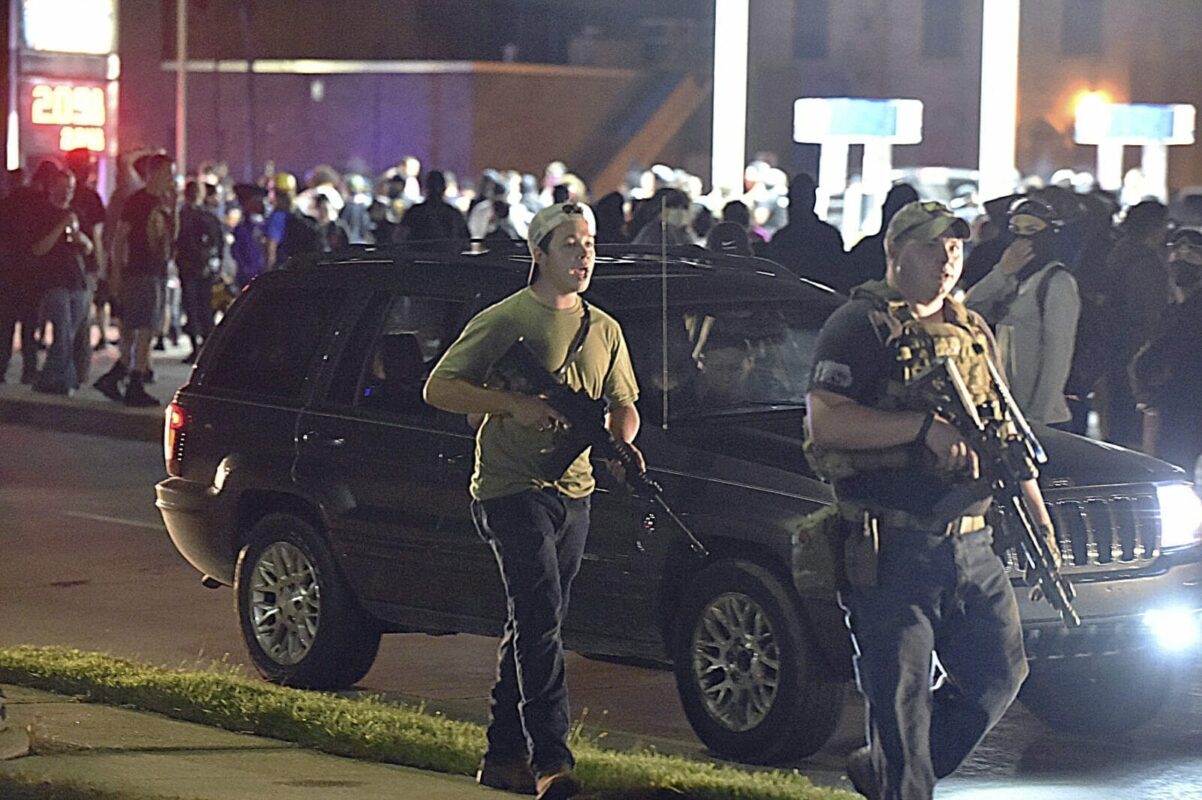 Kyle Rittenhouse, left, with backwards cap, walks along Sheridan Road in Kenosha, Wis., Tuesday, Aug. 25, 2020, with another armed civilian. Prosecutors on Thursday, Aug. 27, 2020 charged Rittenhouse, a 17-year-old from Illinois in the fatal shooting of two protesters and the wounding of a third in Kenosha, Wisconsin, during a night of unrest following the weekend police shooting of Jacob Blake. (Adam Rogan/The Journal Times via AP)