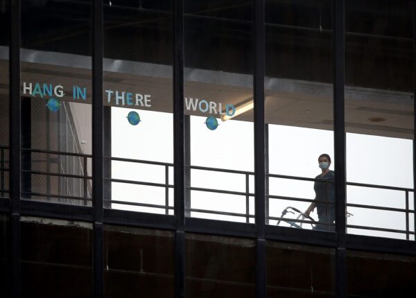 A sign that reads "HANG IN THERE WORLD" is seen in the windows of the enclosed walkway at Thomas Jefferson University Hospital in Philadelphia. State officials are asking hospitals to work together as some face a staffing crisis. (DAVID MAIALETTI / Philadelphia Inquirer)