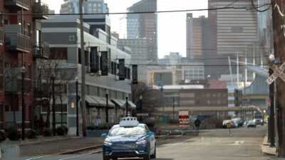 In this Dec. 18, 2018, photo, one of the test vehicles from Argo AI, Ford's autonomous vehicle unit, navigates through the strip district near the company offices in Pittsburgh. In the world of autonomous vehicles, Pittsburgh, Phoenix and Silicon Valley are bustling hubs of development and testing. But ask those involved in self-driving vehicles when we might actually see them carrying passengers in every city, and you'll get an almost universal answer: Not anytime soon. An optimistic assessment is 10 years. Many others say decades as researchers try to conquer a number of obstacles. (AP Photo/Keith Srakocic)