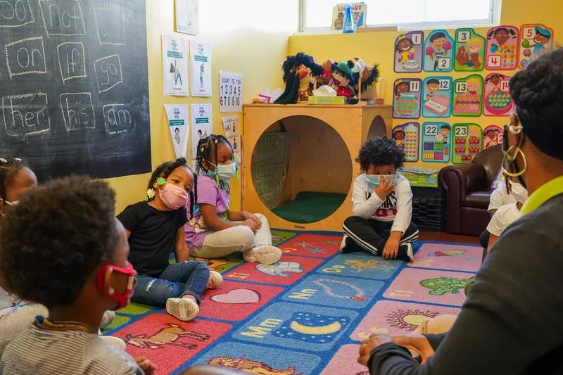 Tanisha Baylor (right) during “circle time” with the 4-year-old students under her care at The Willow School. The Montgomery County center for children has been significantly impacted by staffing shortages.