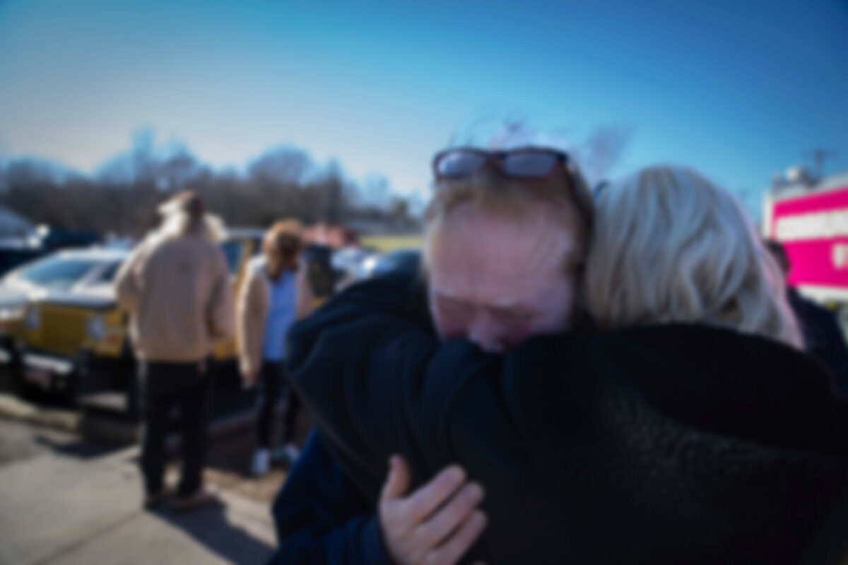 Tamara Yekinni hugs a friend outside a shelter in Wingo, Ky., on Sunday, Dec. 12, 2021, after residents were displaced by a tornado that caused severe damage in the area. Yekinni is an employee at a candle factory where employees were killed and injured by the storm. (AP Photo/Robert Bumsted)