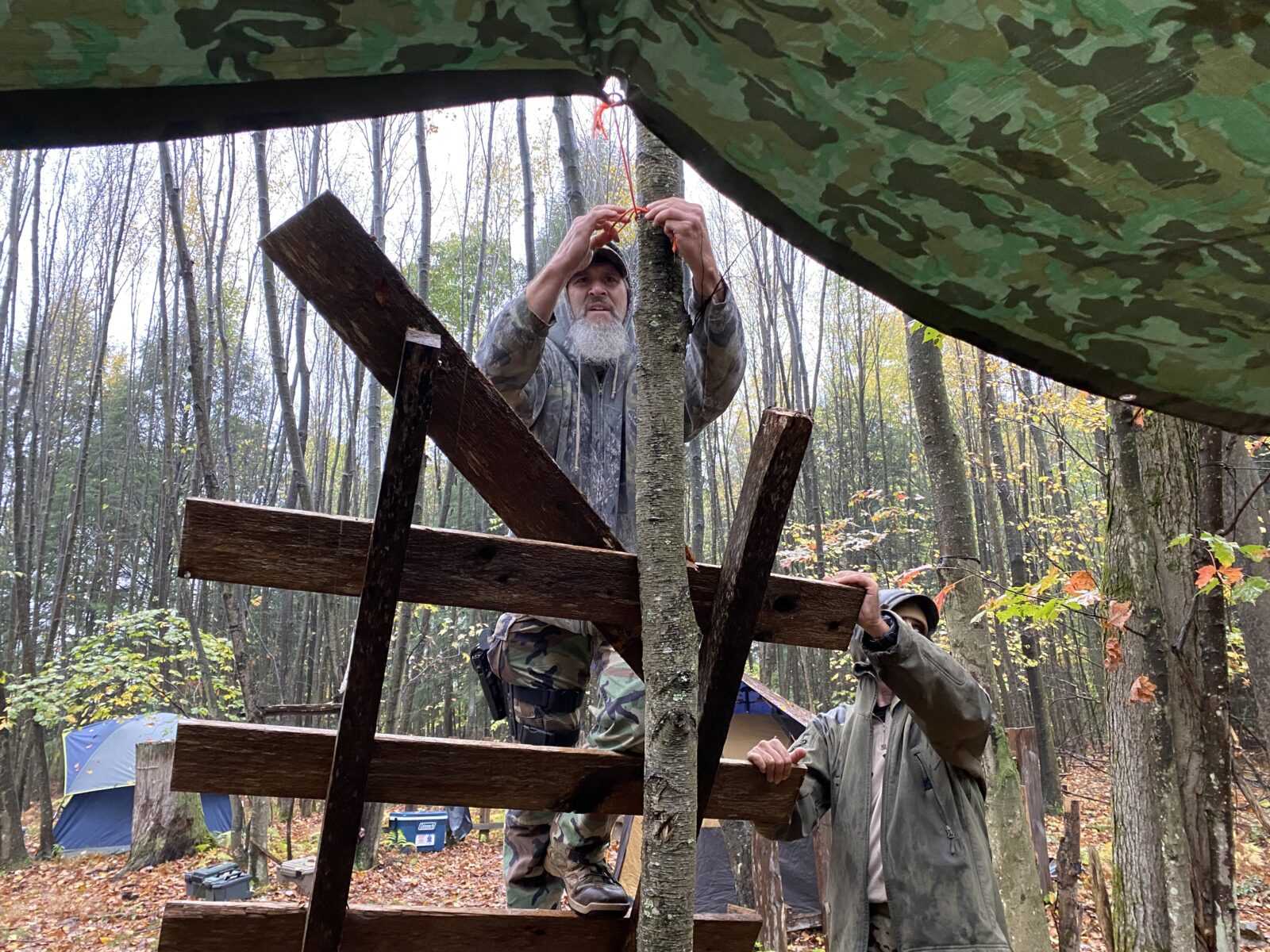 A member of the Pennsylvania Volunteer Militia hangs a tarp during a rainstorm in a remote part of Pennsylvania’s Allegheny Plateau in October. Militias like the Pennsylvania Volunteers have come out to the streets as a kind of self-appointed security presence at protests in recent years, something some experts say ratchets up tensions.