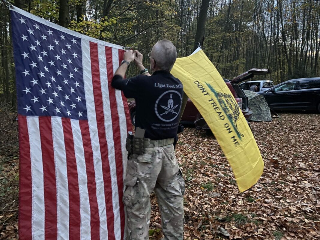 Bob Gardner hangs up the Gadsden flag next to the American flag at a training camp for the Pennsylvania Volunteer Militia. The Gadsden Flag has become a symbol of militias and other far-right groups. As Gardner put it, it represents “Don’t fuck with me.”