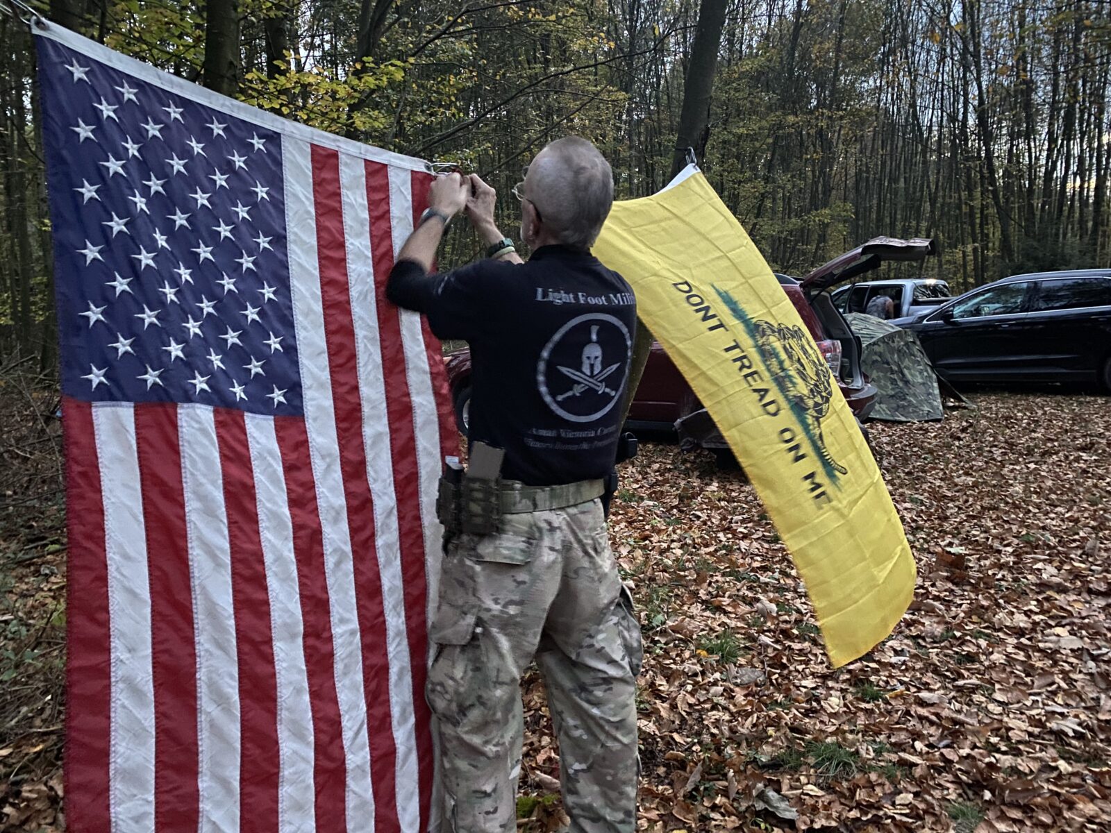 Bob Gardner hangs up the Gadsden flag next to the American flag at a training camp for the Pennsylvania Volunteer Militia. The Gadsden Flag has become a symbol of militias and other far-right groups. As Gardner put it, it represents “Don’t fuck with me.”