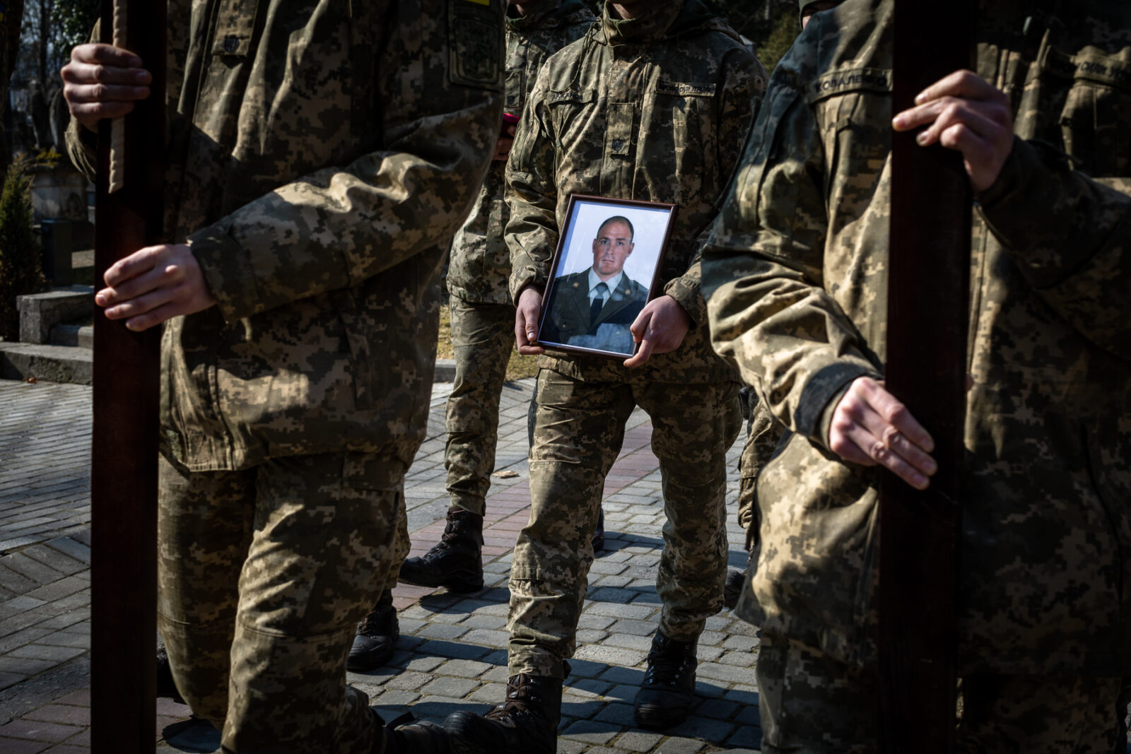 Ukrainian soldiers holding the photo of one of the 35 soldiers killed from the bombing of the International Peacekeeping and Security Center in Yavoriv outside of Lviv near the border with Poland Sunday morning. They were laid to rest at the Lychakiv Cemetery in Lviv, Ukraine.