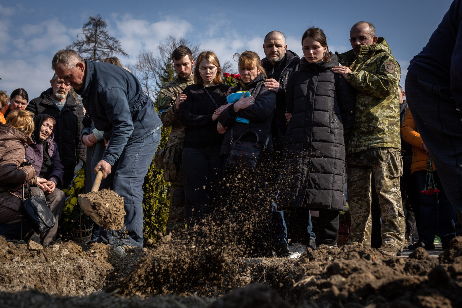 Relatives of one of the 35 soldiers killed from the bombing of the International Peacekeeping and Security Center in Yavoriv outside of Lviv near the border with Poland watch as their loved on is buried in the military section of the Lychakiv Cemetery in Lviv, Ukraine.