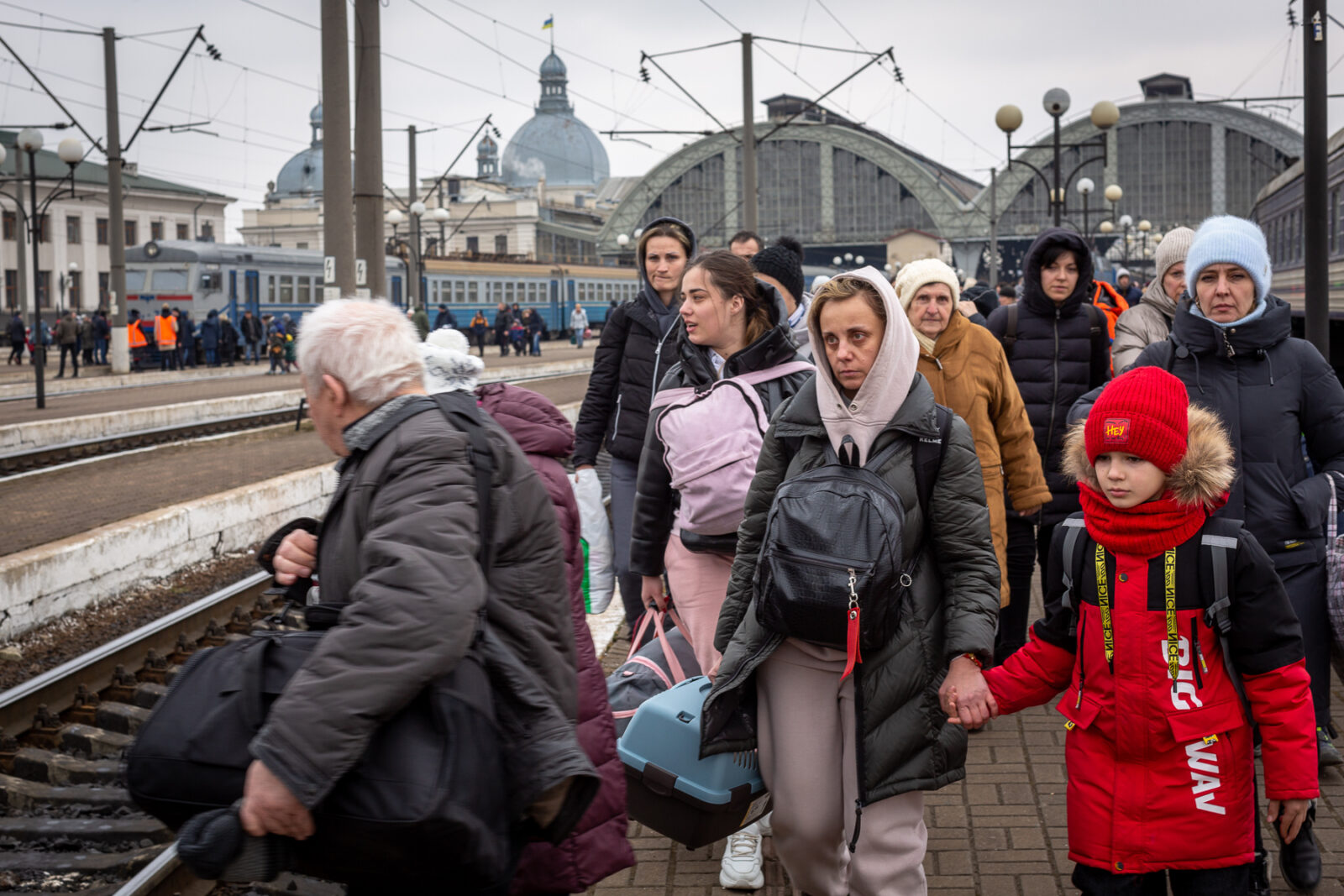 March 5: As the exodus from Ukraine intensifies, the Lviv railway station has become engulfed with people. Lviv is located about 50 miles from the Polish border. Here, families walk over the rail lines to get to the station.