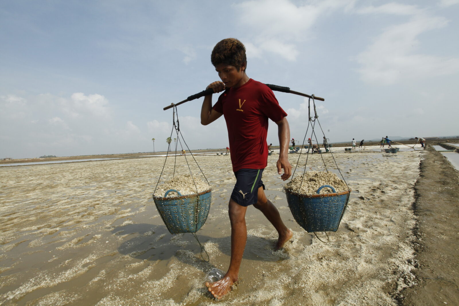 A Burmese salt worker carrying a heavy salt basket from the salt field near the beach of Mon state, Thaphyuzayet township, Burma, on May 6, 2016. (Hong Sar)