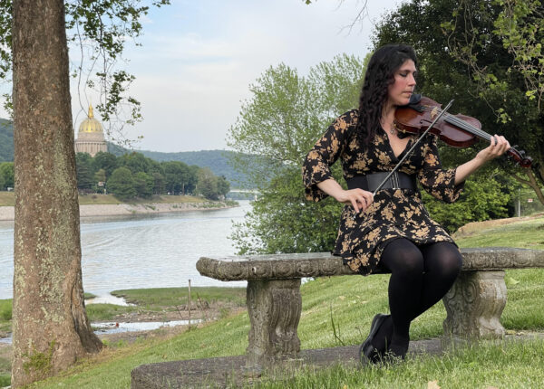 Musician and teacher Alasha Al-Qudwah make music along the banks of the Kanawha River in Charleston.