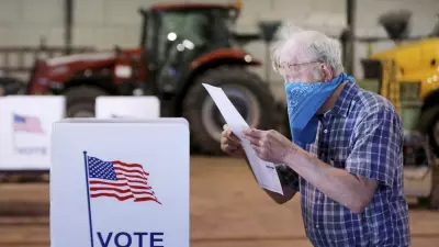 Robert Wilson reviews his selections on his ballot while voting at the town's highway garage building Tuesday, April 7, 2020 in Dunn, Wis. Voters in Wisconsin are waiting in line to cast ballots at polling places for the state's presidential primary election, ignoring a stay-at-home order over the coronavirus threat. (John Hart/Wisconsin State Journal via AP)