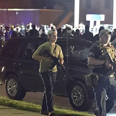 Kyle Rittenhouse, left, with backwards cap, walks along Sheridan Road in Kenosha, Wis., Tuesday, Aug. 25, 2020, with another armed civilian. Prosecutors on Thursday, Aug. 27, 2020 charged Rittenhouse, a 17-year-old from Illinois in the fatal shooting of two protesters and the wounding of a third in Kenosha, Wisconsin, during a night of unrest following the weekend police shooting of Jacob Blake. (Adam Rogan/The Journal Times via AP)