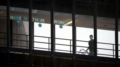 A sign that reads "HANG IN THERE WORLD" is seen in the windows of the enclosed walkway at Thomas Jefferson University Hospital in Philadelphia. State officials are asking hospitals to work together as some face a staffing crisis. (DAVID MAIALETTI / Philadelphia Inquirer)