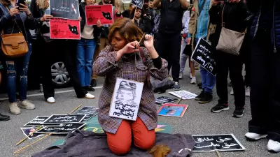 A woman cuts her hair during a demonstration in front of the Iranian embassy in Brussels, Belgium on Sept. 23, 2022, following the death of Mahsa Amini.