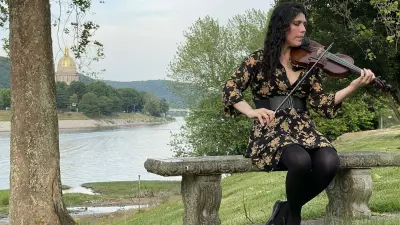 Musician and teacher Alasha Al-Qudwah make music along the banks of the Kanawha River in Charleston.